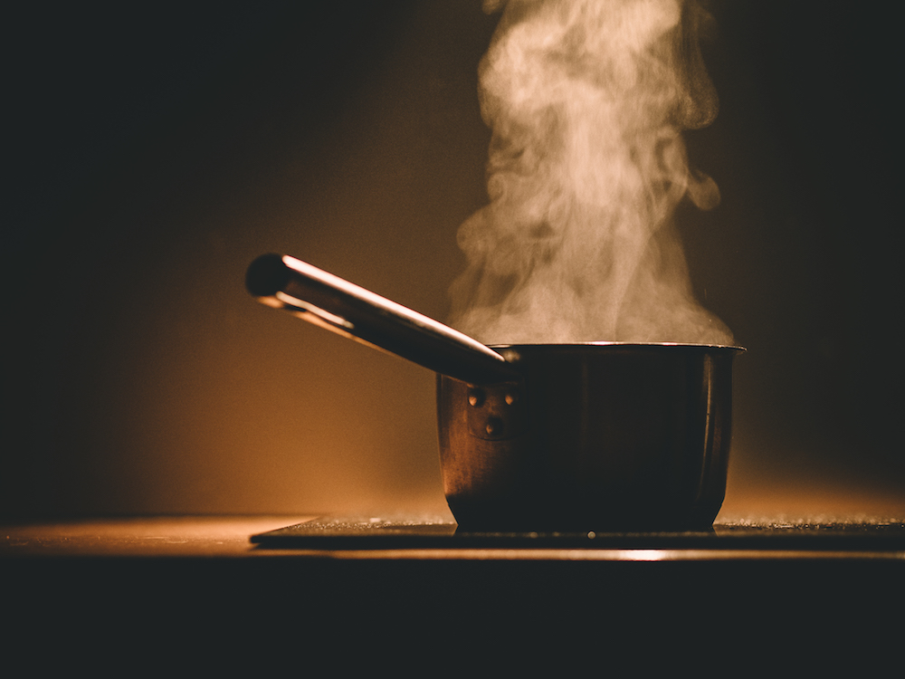 a pot cooking on the stove with steam rising