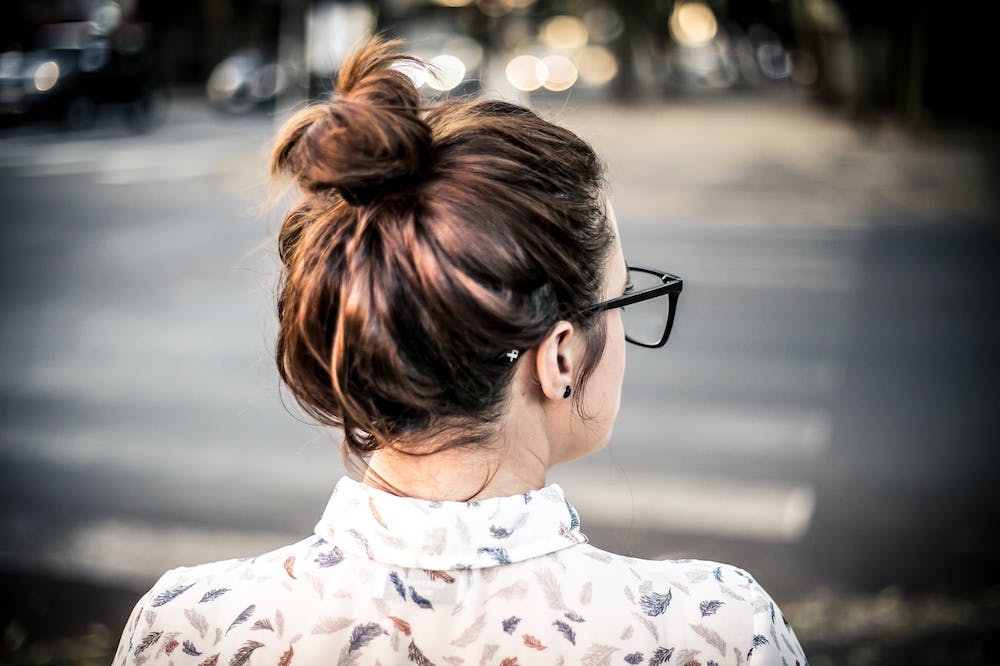 a woman standing on the curb looking to cross the street