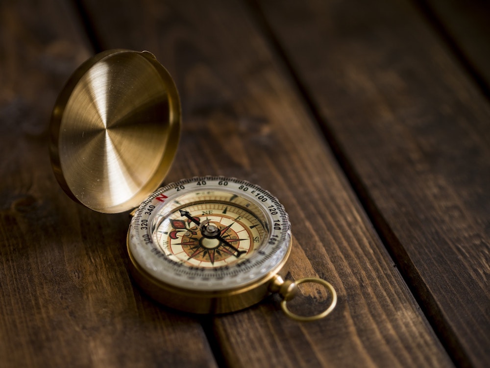 compass laying on a wood table