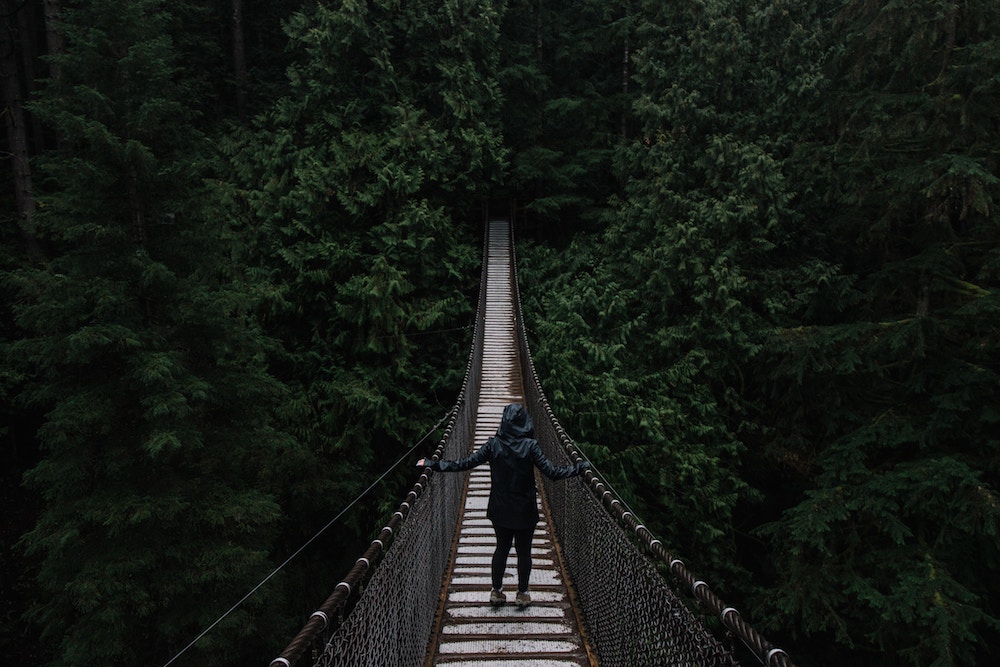 woman facing her fear crossing a bridge