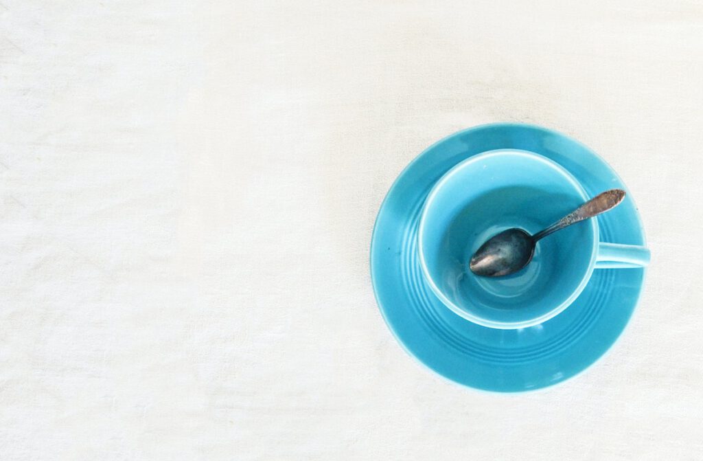 a blue cereal bowl with a spoon and no cereal inside, just empty