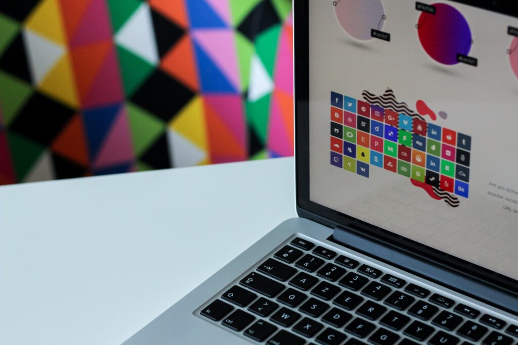 Cool WordPress Plugins: a laptop on top of a table with a very colorful wallpaper in the background