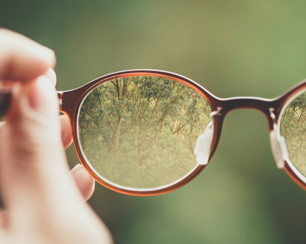 life lessons learned: someone looking through a pair of glasses that they're holding