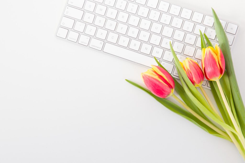 website content ideas: bouquet of tulips laying on top of a white computer keyboard