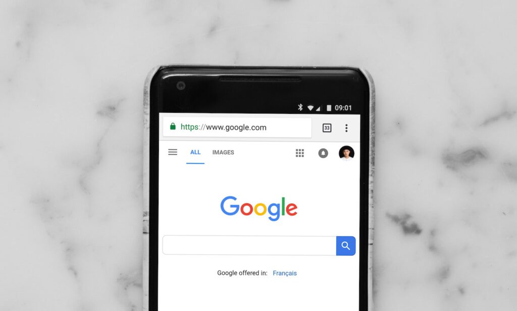 Best WordPress plugins for SEO and Better Page rank: Google PoGoogle front page on a cell phone sitting on top of a marble countertop