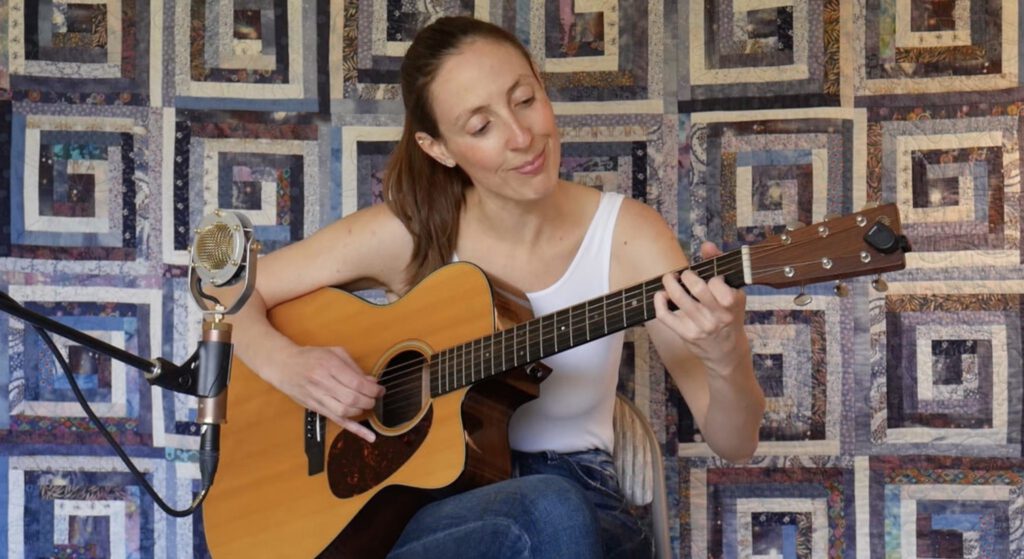 Janelle Haskell playing guitar