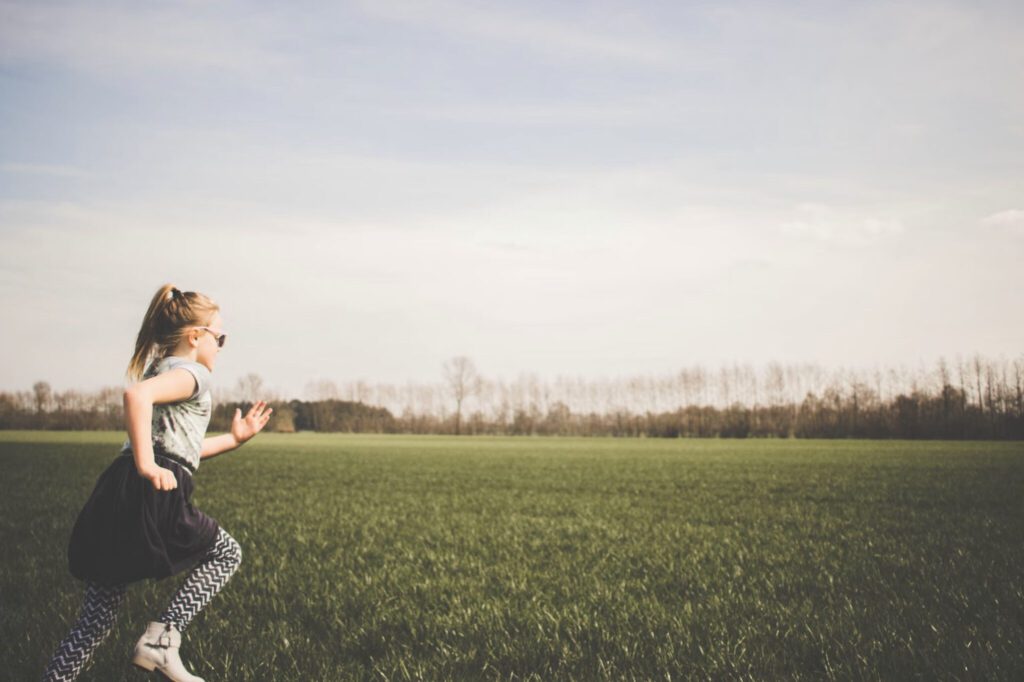 young girl running in an open field