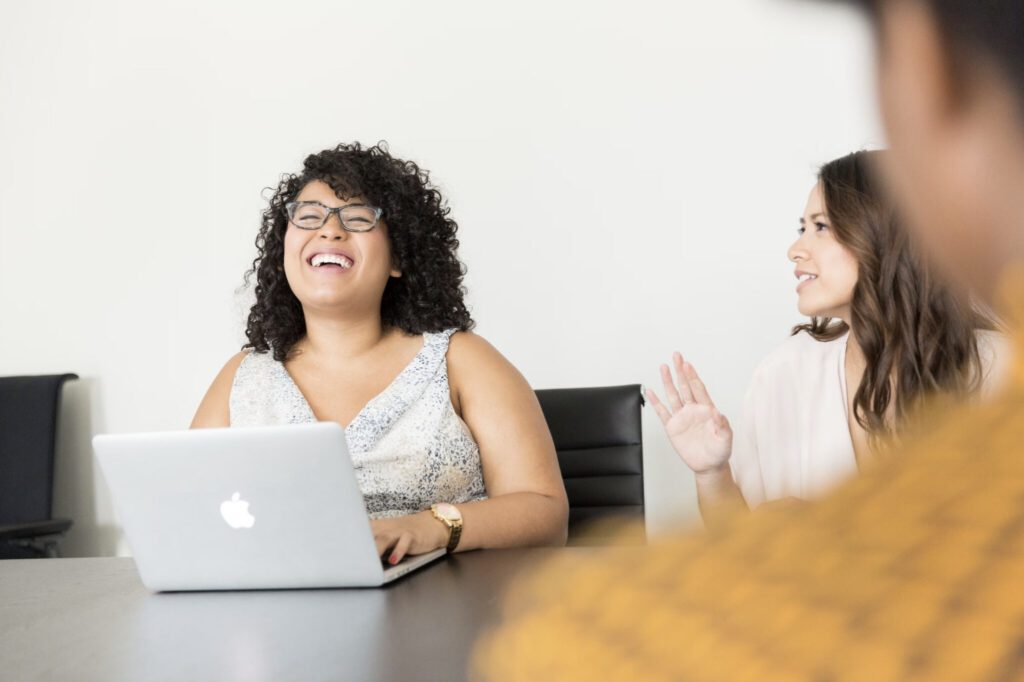 work peers or colleagues working together laughing