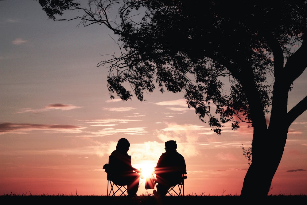 two people sitting in the park talking