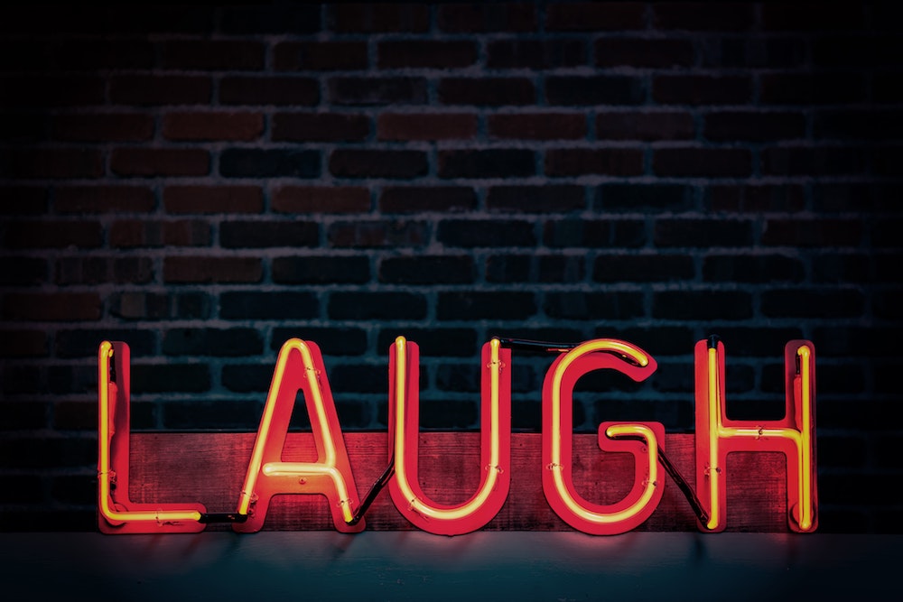 neon sign that says LAUGH