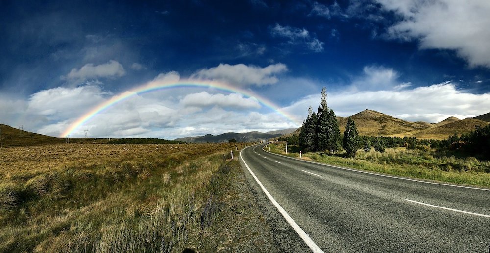 a beautiful country road with rainbow