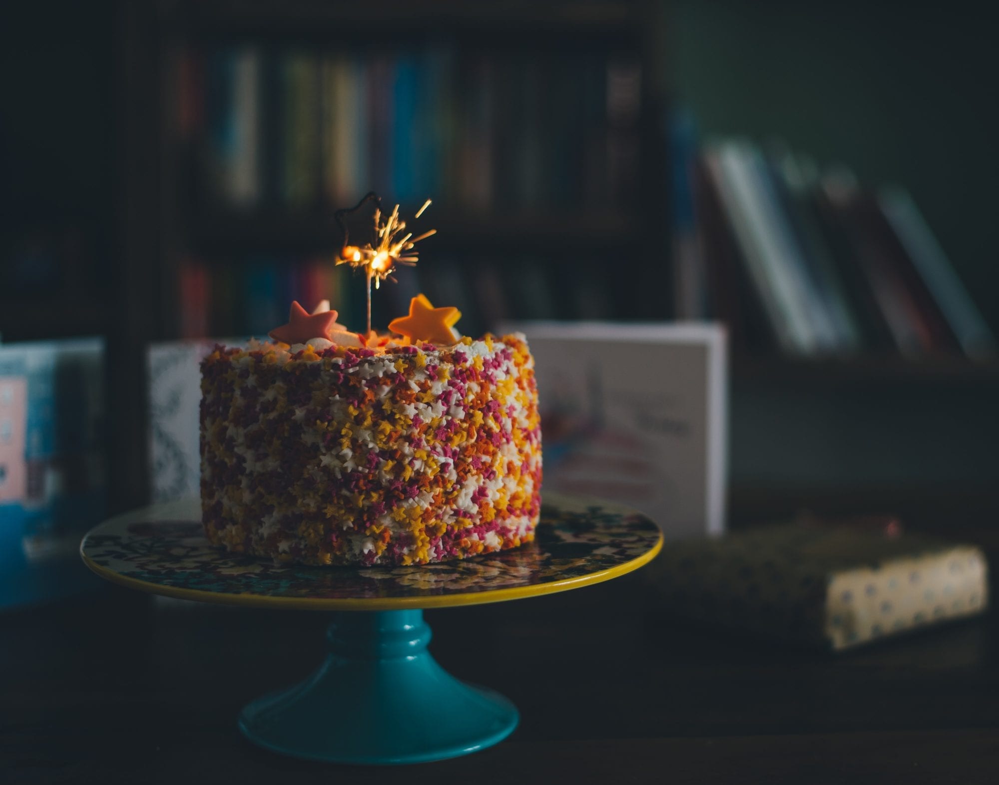 how to have the best vacation ever: a colorful birthday cake with sprinkles on top and one birthday candle