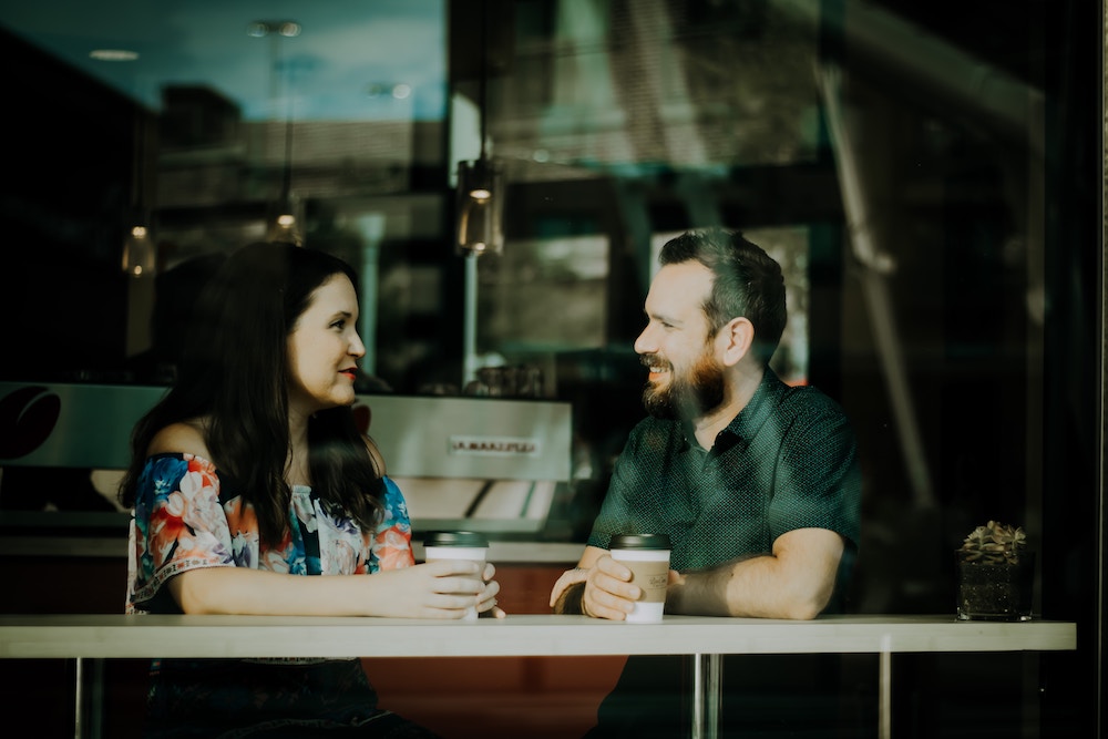 how to have better conversations - mand and woman chatting in a coffee shop