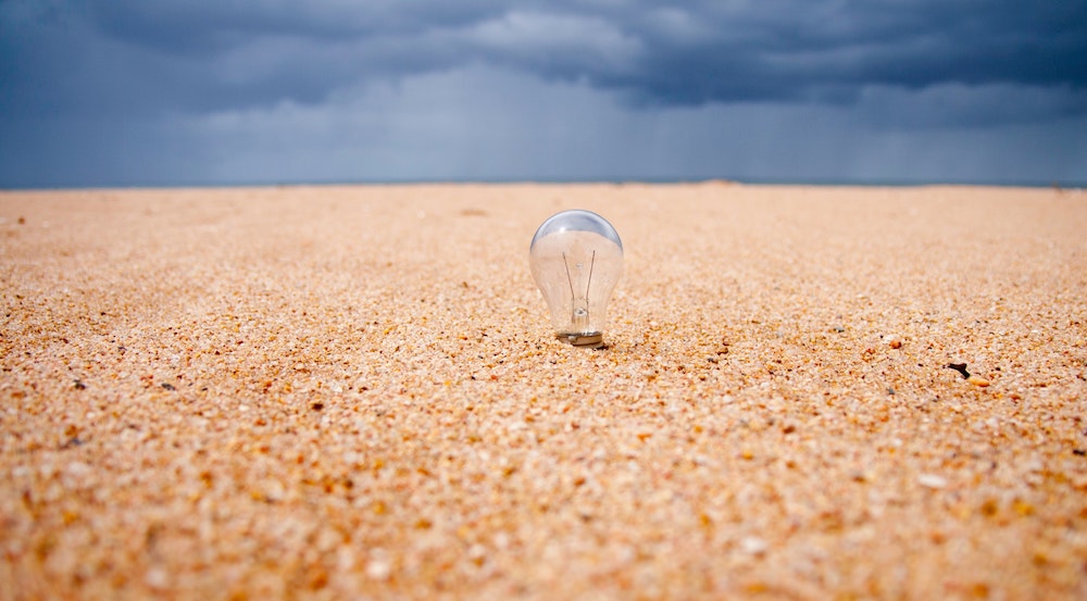 quick problem solving - a light bulb sitting in the sand on a beach