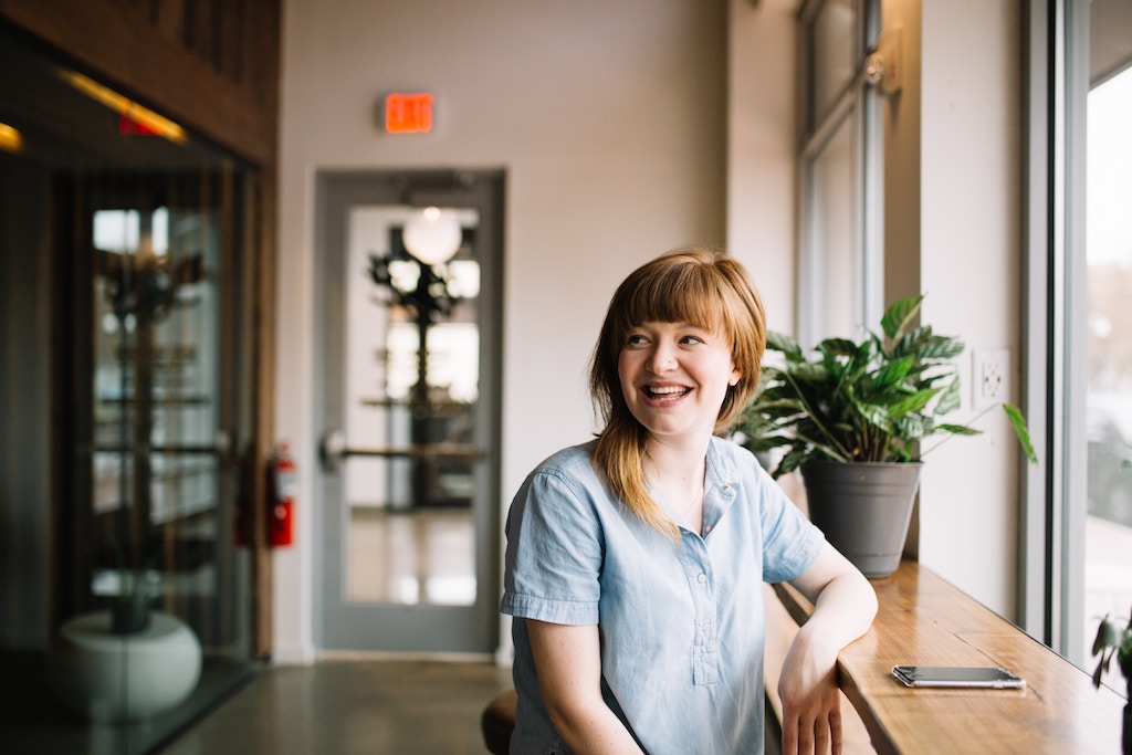 keys to successful client relationships - a woman sitting at a coffee shop bar laughing