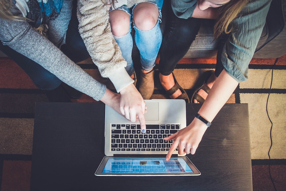 Overcoming Limiting Beliefs - three people sitting in front of a laptop computer