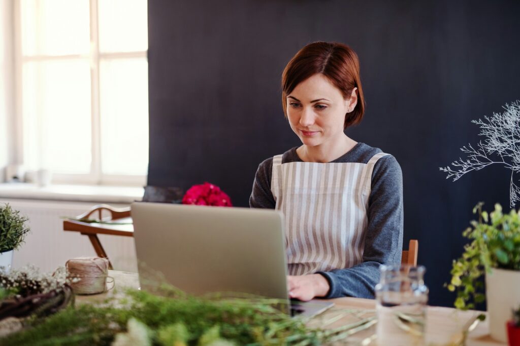 woman working on her website in a flower shop