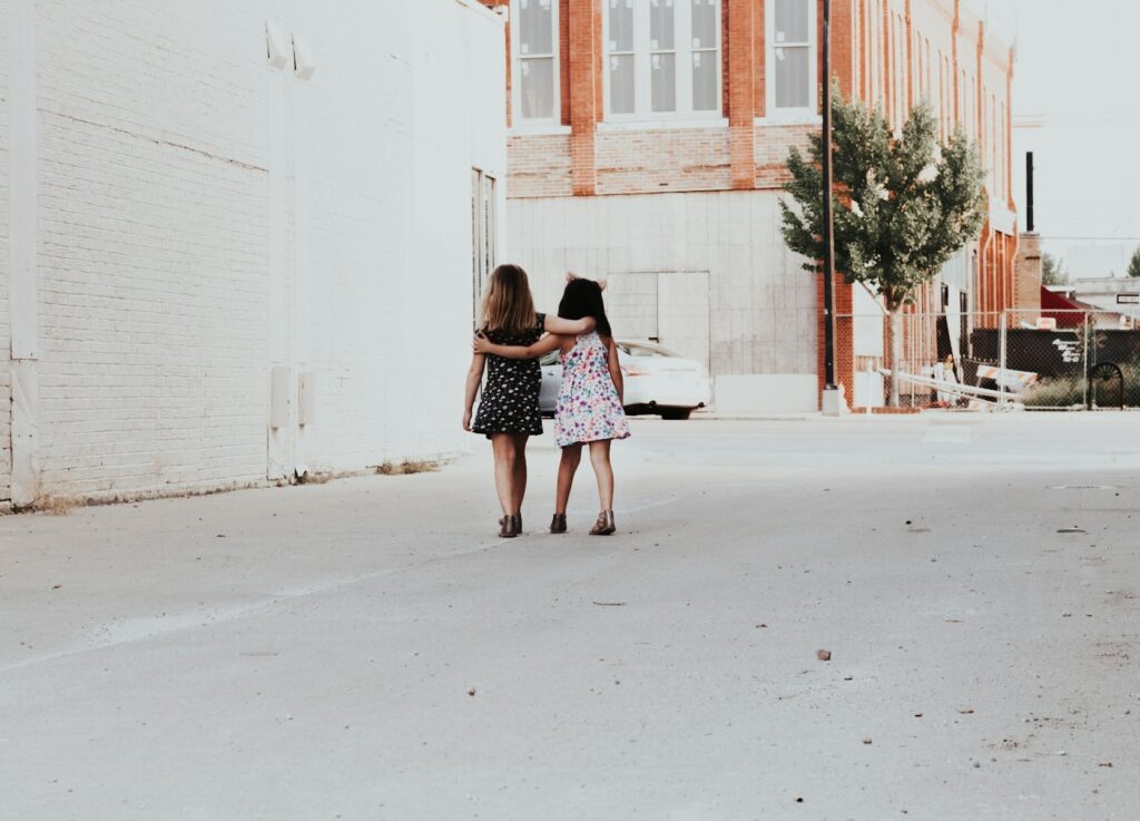 two girls walking arm in arm