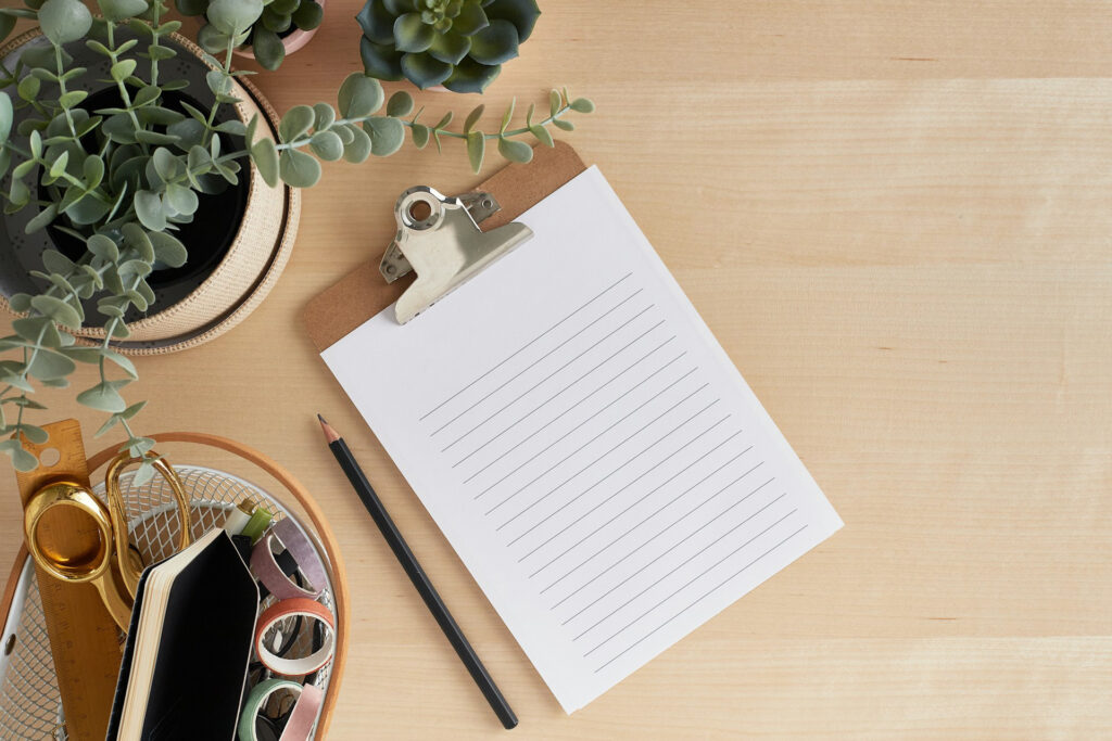 list ideas you'll love - a lined pad of paper on a desk with other items like a plant, scissors, pen, and pencil